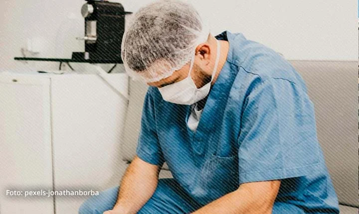 Trabajador de la salud con uniforme médico visiblemente exhausto