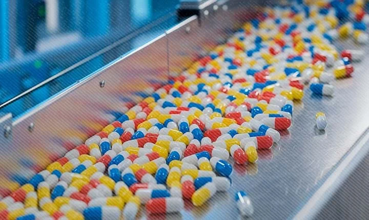 Cápsulas farmacéuticas en cinta industrial de producción