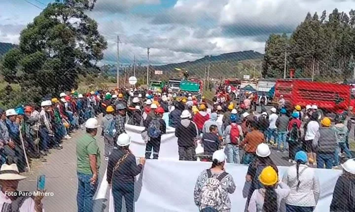 Mineros y campesinos bloquean una carretera en Boyacá durante el paro indefinido, con cascos y camiones atravesados en la vía.