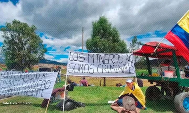 Campesinos y mineros en Boyacá sostienen pancartas con mensajes contra la criminalización de su actividad durante el paro.