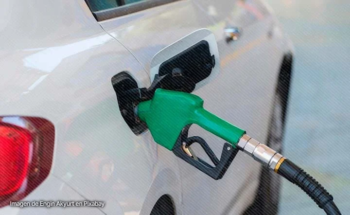 Boquilla verde de estación de servicio suministrando combustible a un automóvil