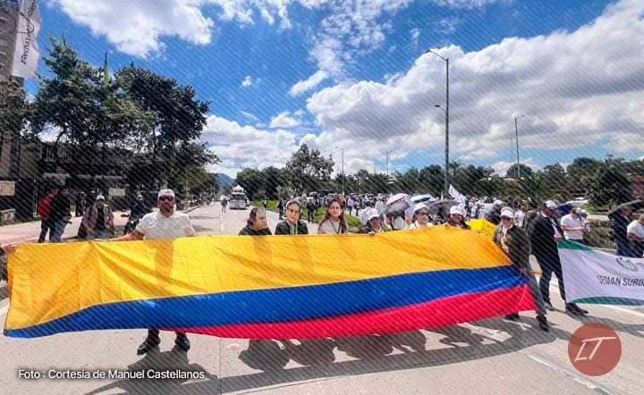 Trabajadores de la DIAN marchan con bandera de Colombia en protesta laboral
