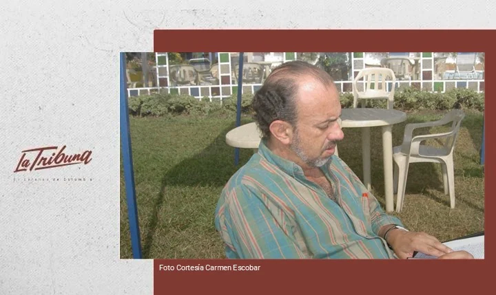 Enrique Daza Gamba sentado al aire libre revisando documentos en mesa