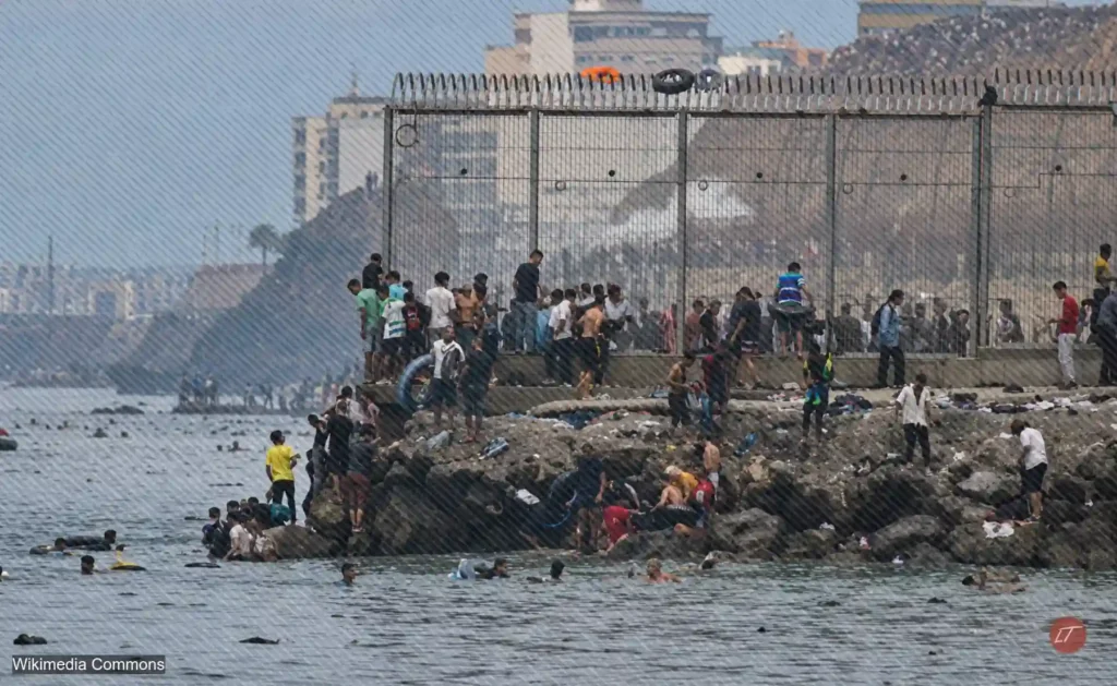 Migrantes cruzan una zona costera junto a la frontera de Ceuta