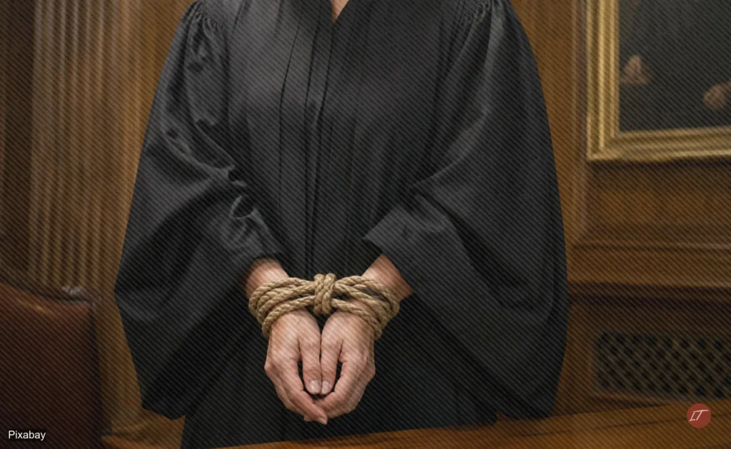 Juez con toga tiene las manos atadas en sala judicial
