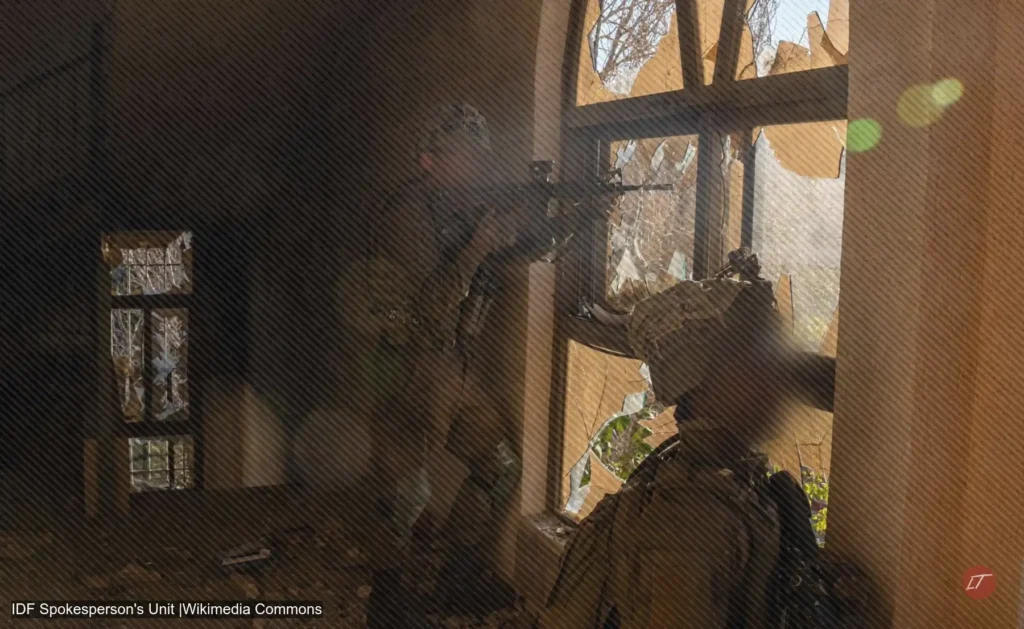 Soldado israelí observa por una ventana rota en el sur del Líbano