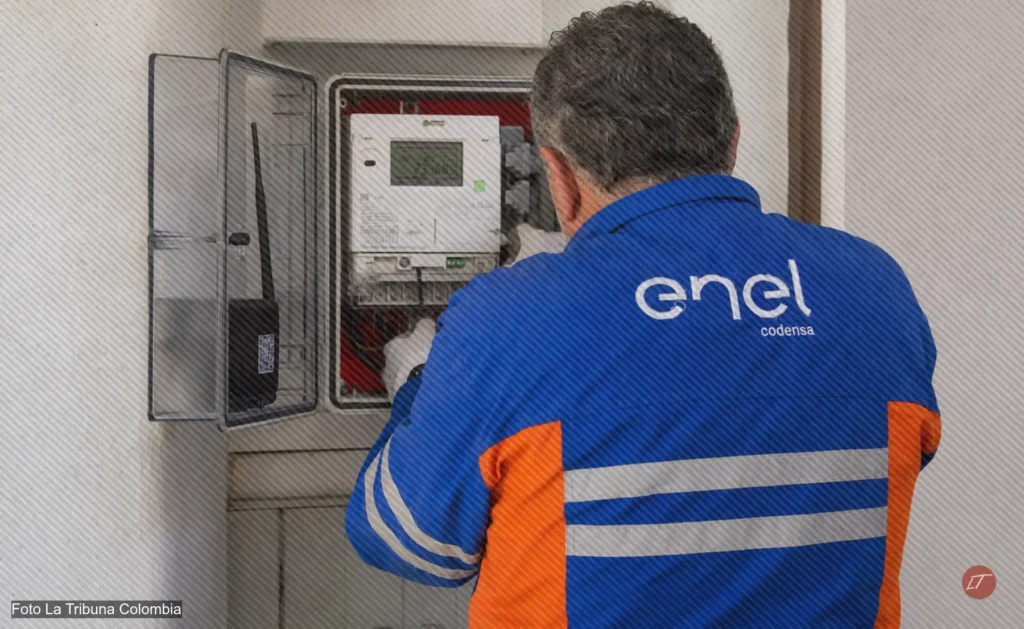 Técnico de espaldas revisa un medidor eléctrico con uniforme azul de Enel