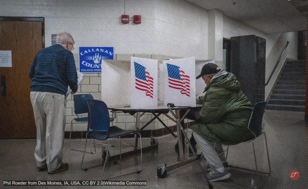 Dos votantes llenan papeletas en cubículos electorales de Estados Unidos