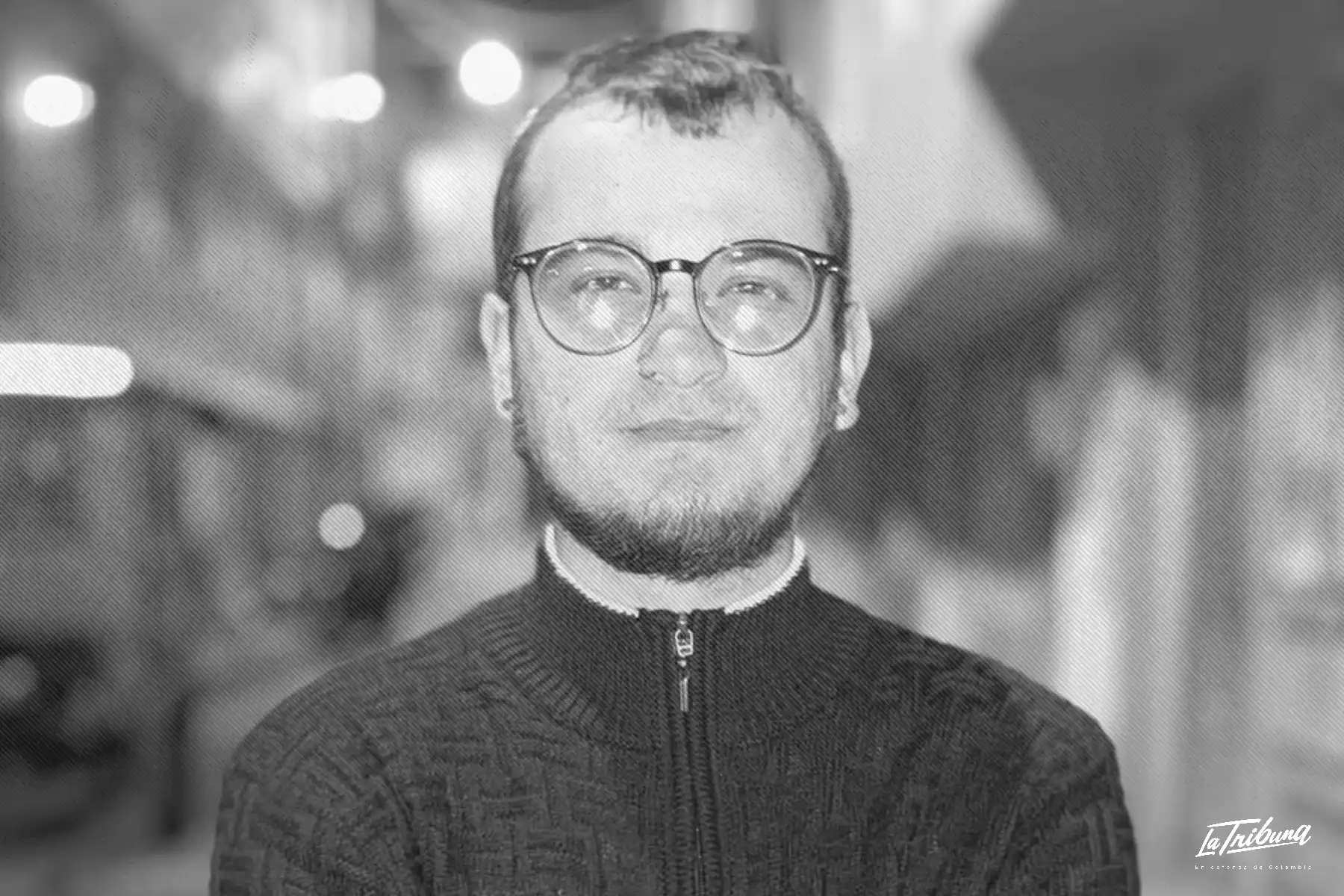Dilan Neira, estudiante universitario, posa con gafas oscuras y pañuelo en un patio