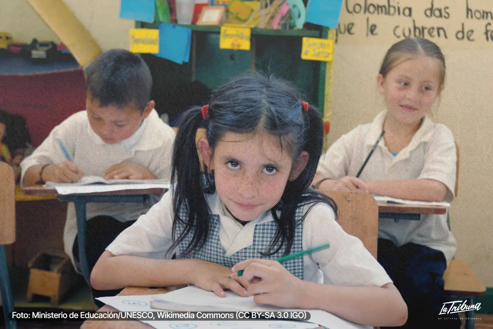 Niña sostiene un lápiz frente a su cuaderno en un aula de Florida, Valle